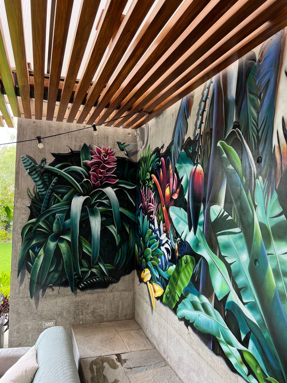 Corner view of 3D tropical botanical mural on covered terrace showing depth illusion and exotic plant details