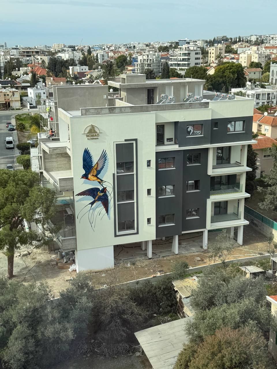 Close-up detail of hyperrealistic swallow mural on building facade showing 3D shadow effects and depth