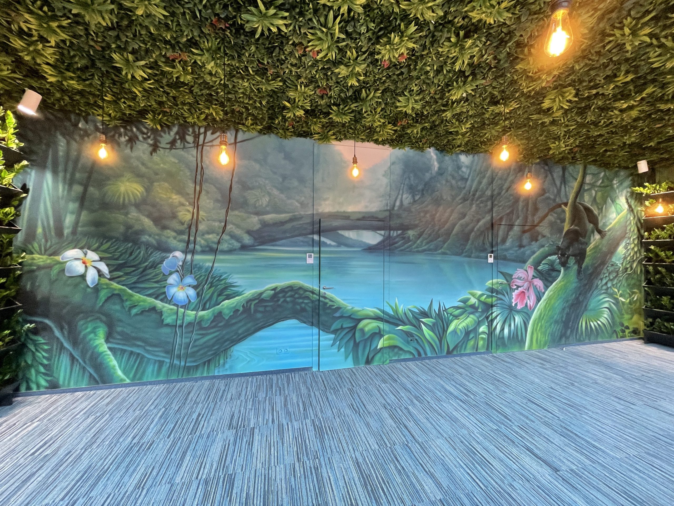 Complete panoramic view of tropical jungle interior mural with turquoise water and foliage canopy