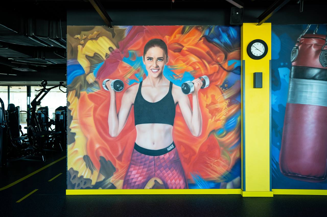 Detailed view of airbrushed fitness athlete portrait with weight plate on abstract painted background