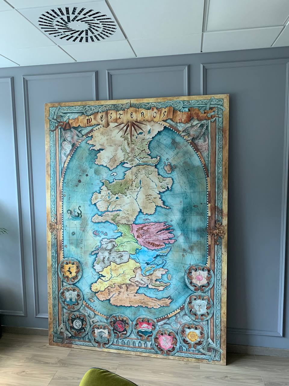 Large Westeros fantasy map canvas painting leaning against wall showing full composition with house crests