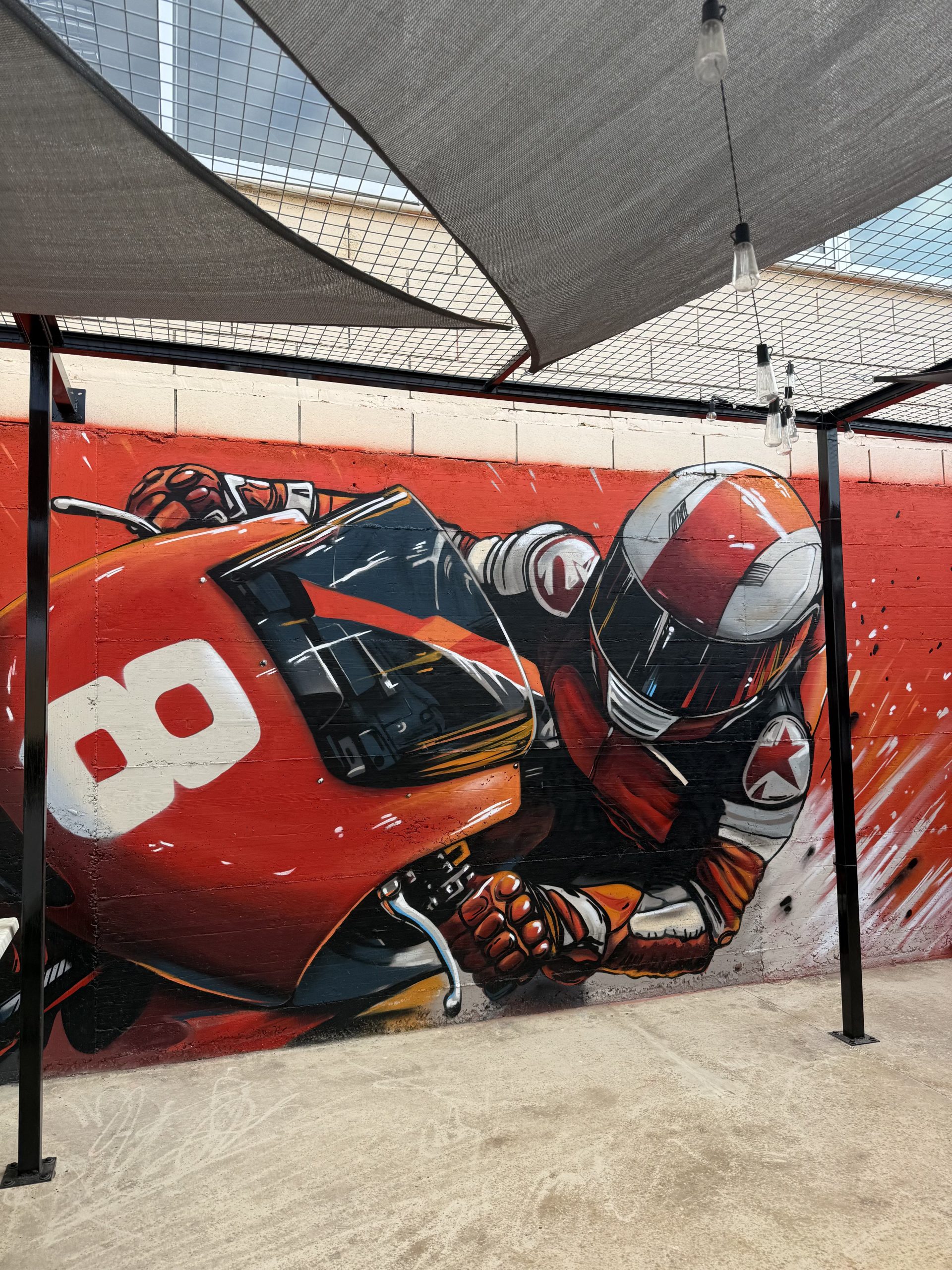 Exterior racing track mural showing motorcycle racer in dynamic pose
